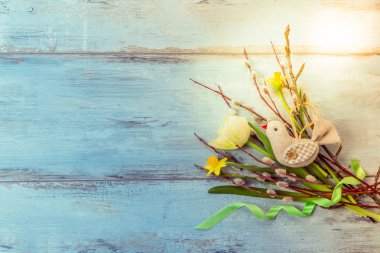 Paskalya yumurtaları ve bahar çiçekleriyle paskalya arkaplanı. Kopyalama alanı olan üst görünüm