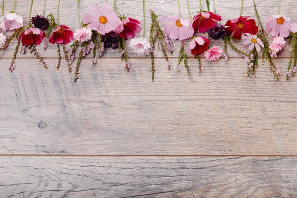 Un ramo de flores blancas cosmética o cosmos con cinta en tablas blancas. Flores amarillas jardín sobre fondo de mesa de madera hecha a mano. Fondo con espacio de copia . — Foto de Stock