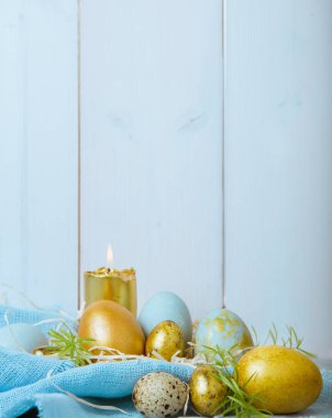 Paskalya yumurtaları ve bahar çiçekleriyle paskalya arkaplanı. Kopyalama alanı olan üst görünüm