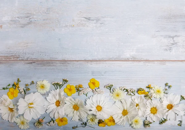 Kytice bílých květů cosmea nebo cosmos s mašlí na bílé tabule. Zahradní květiny žluté pozadí ručně vyrobený dřevěný stůl. Pozadí s kopií prostor. — Stock fotografie