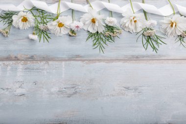 Beyaz çiçekler cosmea veya evren ile şerit beyaz tahtalar üzerinde bir buket. El yapımı ahşap masa arka plan üzerinde Bahçe sarı çiçekler. Zemin kopya alanı ile.