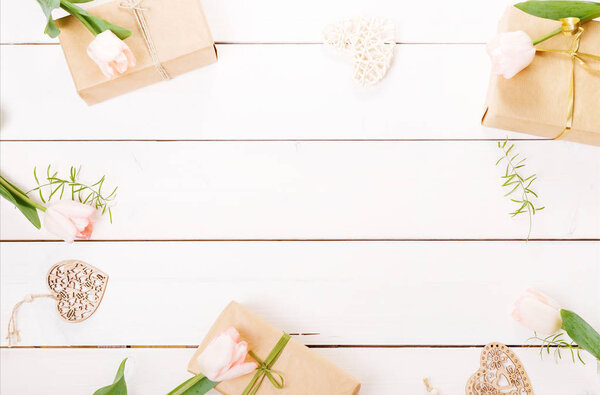 Gift and roses on wooden white background. Workspace. Top view, flat lay