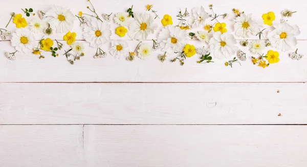 Kytice bílých květů cosmea nebo cosmos s mašlí na bílé tabule. Zahradní květiny žluté pozadí ručně vyrobený dřevěný stůl. Pozadí s kopií prostor. — Stock fotografie