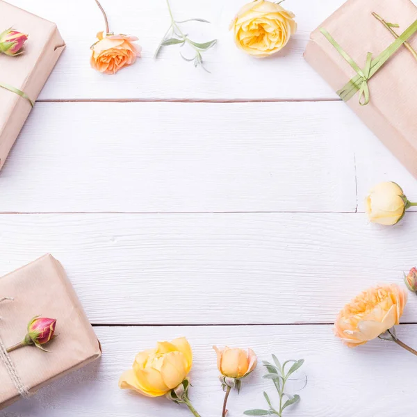 Composición de flores. Regalos y flores de rosas en mesa de madera blanca. Día de la Mujer. Piso tendido, vista superior — Foto de Stock