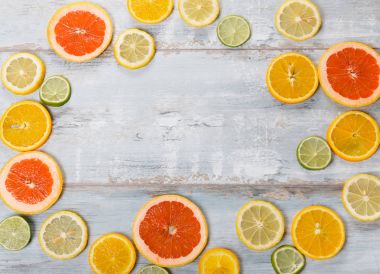 Çerçeve çeşitli narenciye meyve ve marguerite çiçek beyaz arka planda, üstten görünüm