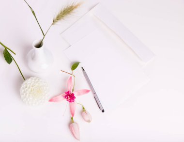 Mektup, kalem ve beyaz çiçekli beyaz arka plan zarfta. Davetiyeler veya aşk mektubu. Doğum günü, anne, Sevgililer, kadın, düğün günü kavramı