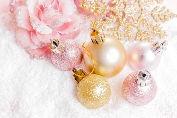 Festive creative gold pink Christmas holiday composition, xmas pink decor holiday ball with ribbon, snowflakes
