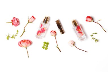 Ahşap arka planda güller olan esaslı aroma yağı. Güllü, kozmetik ürünlü güzellik salonu. Üst Manzara. Düz, kadınsı masa..