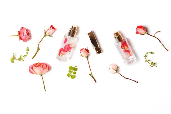 Óleo de aroma essencial com rosas em fundo de madeira. Espaço de trabalho de beleza com rosas, cosméticos. Vista superior. Flat lay casa mesa feminina . — Fotografia de Stock