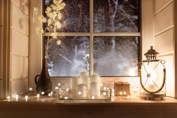 Beautiful burning candles and fairy lights on windowsill indoors — Stock Photo, Image