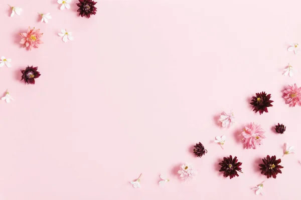 Composición de flores festivas. Marco hecho de flores pequeñas de color rosa y púrpura sobre fondo rosa . — Foto de Stock