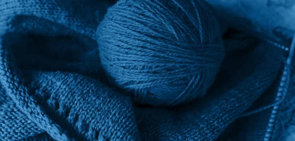 Mavi masanın üzerinde örgü örme işlemi, klasik mavi rengin yün ipliği.