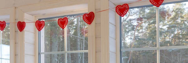 Intérieur de la maison pour la Saint-Valentin avec fenêtre, pendaison coeurs faits main — Photo