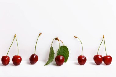 Beyaz zemin üzerinde taze, sulu kirazlar, minimal kompozisyon, minimum tema