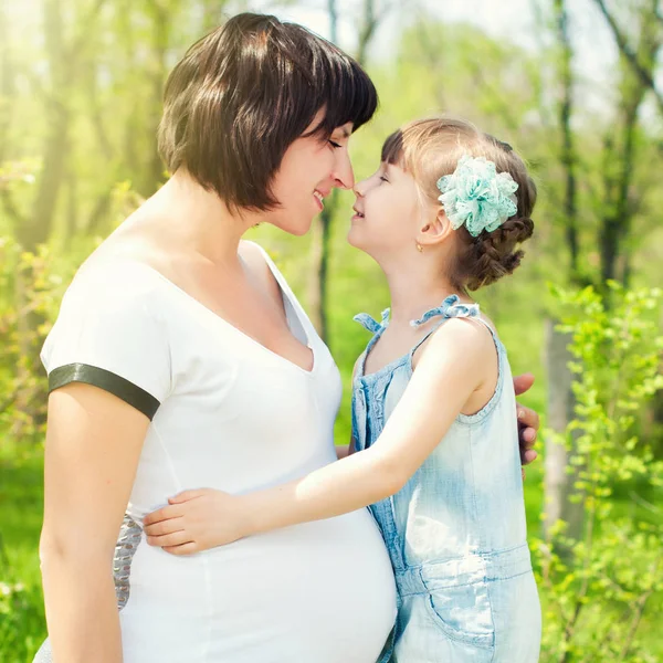 Ευτυχισμένη οικογένεια στο καλοκαίρι. Έγκυος γυναίκα με το παιδί. — Φωτογραφία Αρχείου