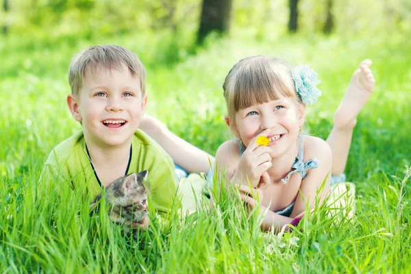 Crianças brincando na grama verde no parque — Fotografia de Stock