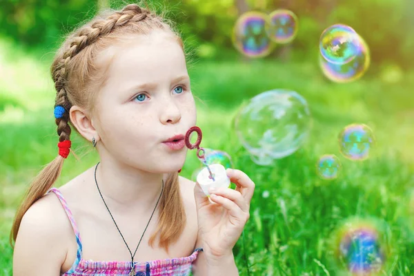 Hermosa pelirroja chica soplando jabón burbujas — Foto de Stock
