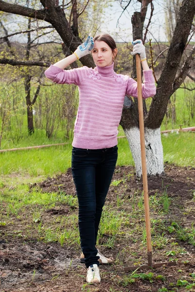 Ung kvinna som arbetar i trädgården. — Stockfoto