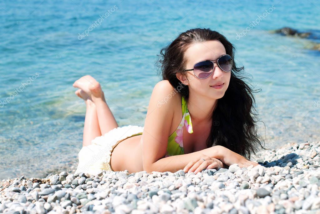 Beautiful Happy Girl is sunbathing on the Beach