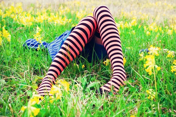 Los pies de la joven acostada en la hierba verde al aire libre en el prado de verano —  Fotos de Stock