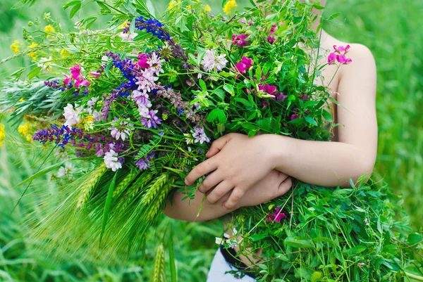 Ευτυχισμένο παιδί το καλοκαίρι. Παιδί με μεγάλο μπουκέτο λουλούδια — Φωτογραφία Αρχείου