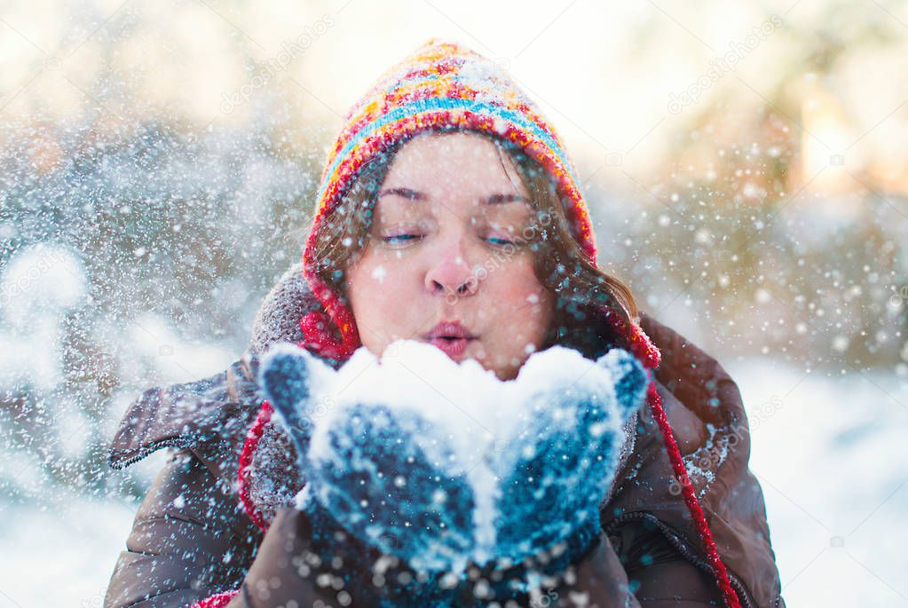 Beauty Winter Girl Blowing Snow in frosty Park
