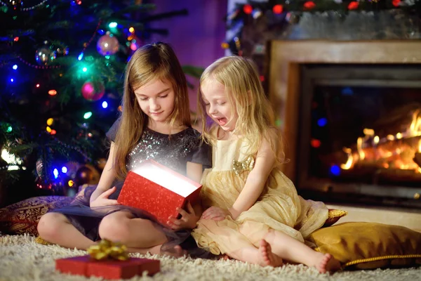 Systrarna öppna magiska julklapp — Stockfoto