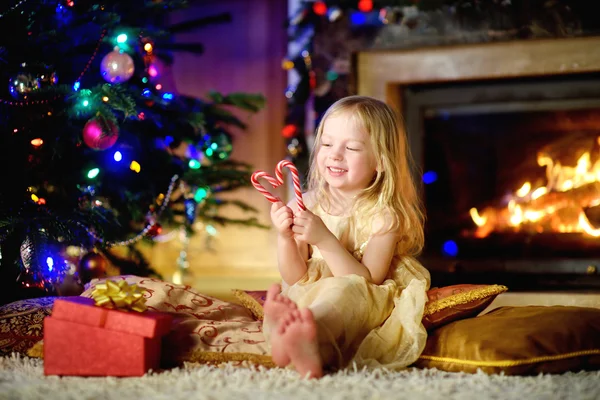 Little girl by a fireplace in a cozy room — ストック写真