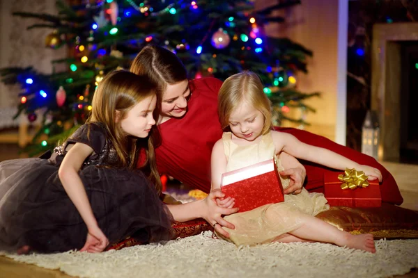 Mother and her daughters unwrapping Christmas gifts — Φωτογραφία Αρχείου