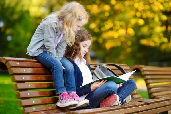 Pequeñas colegialas estudiando en un parque de la ciudad —  Fotos de Stock