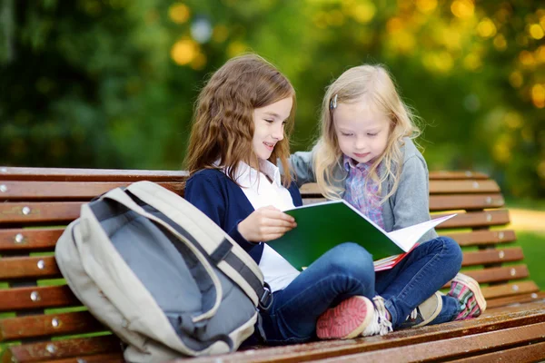 Pequenas alunas estudando em um parque da cidade — Fotografia de Stock