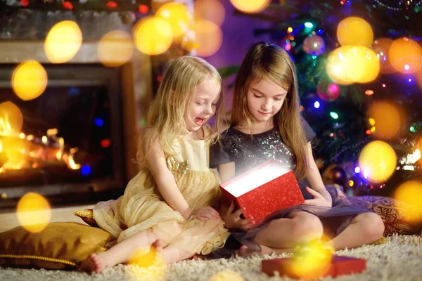 Nővérek megnyitása a varázslatos karácsonyi ajándék — Stock Fotó