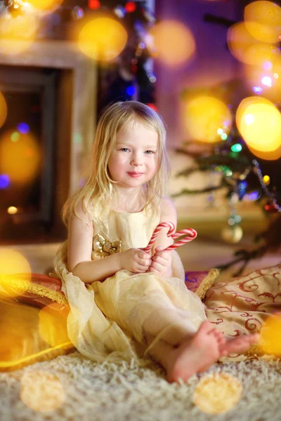 Little girl by a fireplace in a cozy room — Stockfoto