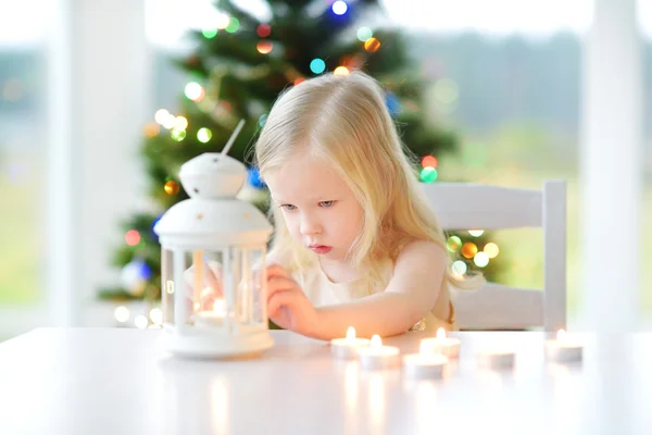 Menina acendendo uma vela na lanterna — Fotografia de Stock