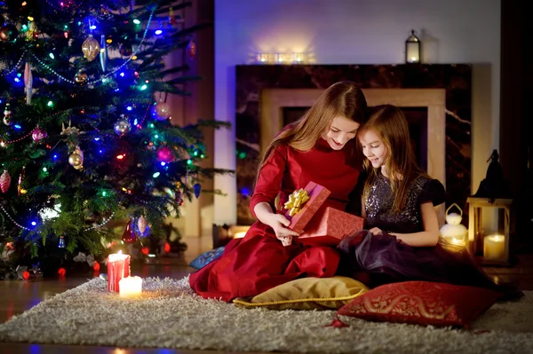 mother and her daughter unwrapping Christmas gift