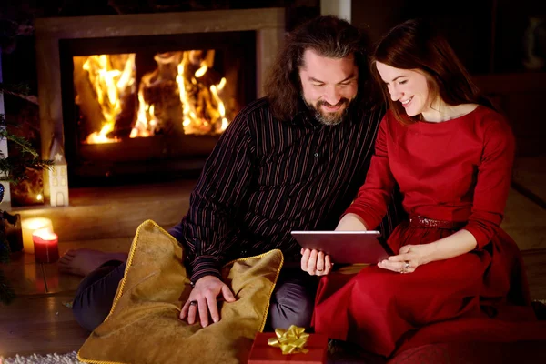 Couple using a tablet pc by a fireplace — Φωτογραφία Αρχείου
