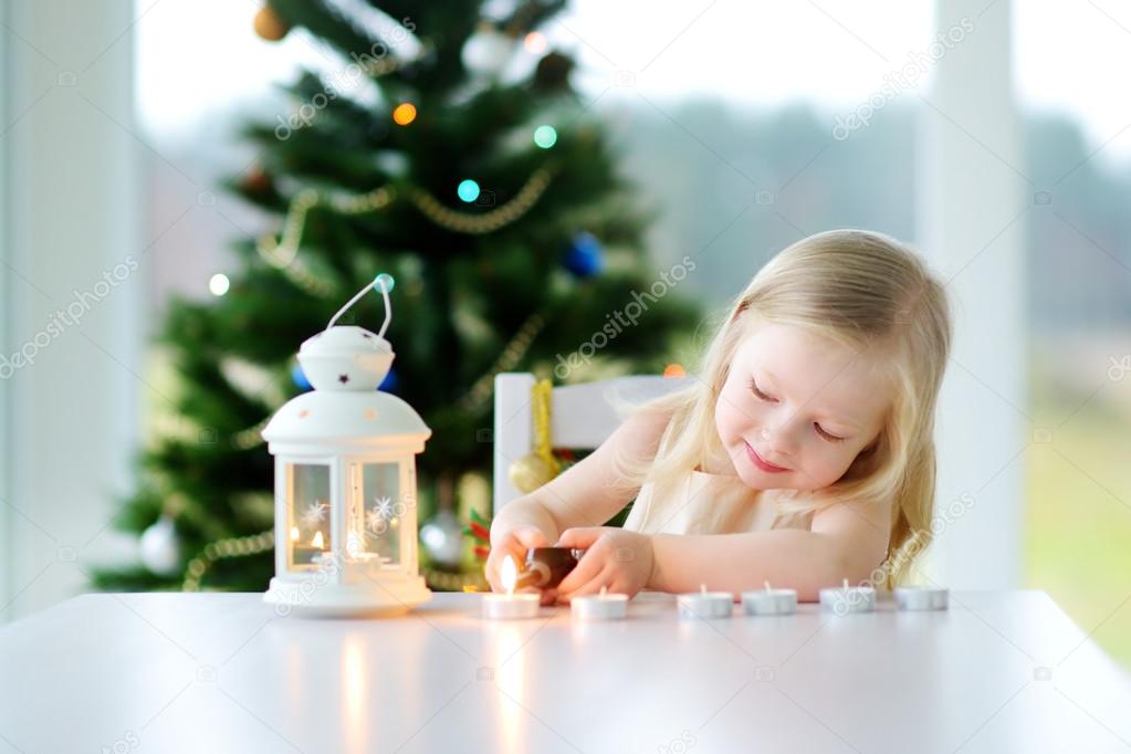 Little girl lighting a candle in lantern