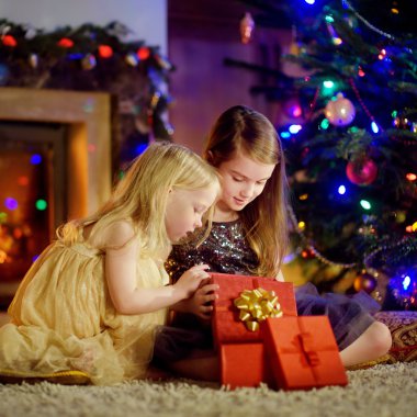 Büyülü Noel hediyesi bir şöminenin yanında açılış kız