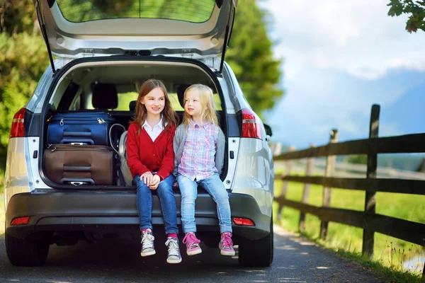 Dos adorables niñitos sentados en un coche antes de irse de vacaciones con sus padres — Foto de Stock