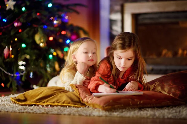 Duas irmãs engraçadas escrevendo uma carta para o Papai Noel — Fotografia de Stock