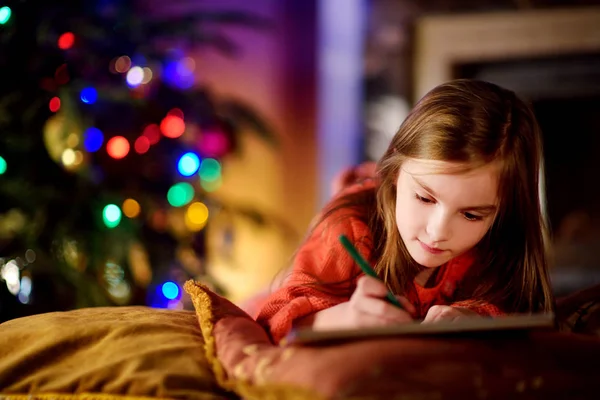 Sevimli küçük kız Noel Baba'ya bir mektup yazma — Stok fotoğraf