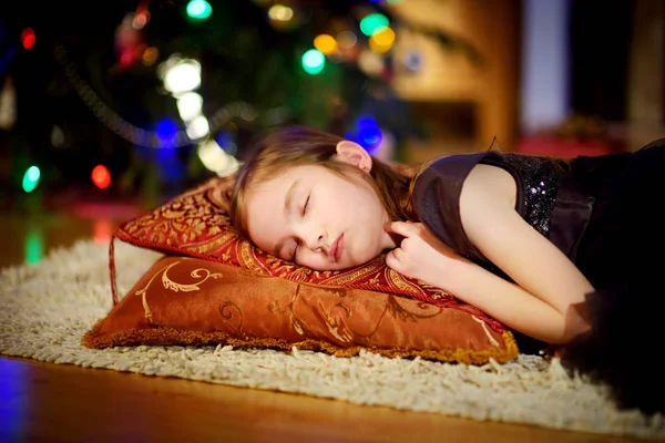Urocza dziewczynka spanie pod choinkę przy kominku — Zdjęcie stockowe