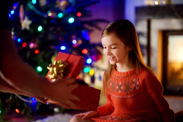 Szczęśliwa dziewczynka coraz świąteczny prezent od jej rodziców — Zdjęcie stockowe