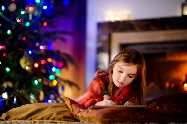 Sevimli küçük kız Noel Baba'ya bir mektup yazma — Stok fotoğraf