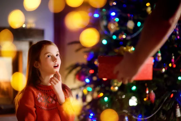 Ευτυχισμένο το μικρό κορίτσι να πάρει ένα δώρο Χριστουγέννων από γονέα — Φωτογραφία Αρχείου