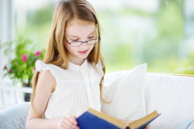 Küçük kız kitap okuyor.