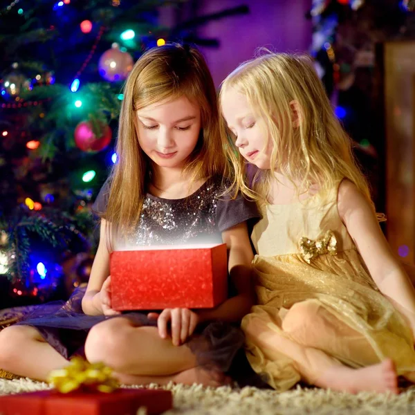 Hermanas felices abriendo regalo de Navidad —  Fotos de Stock