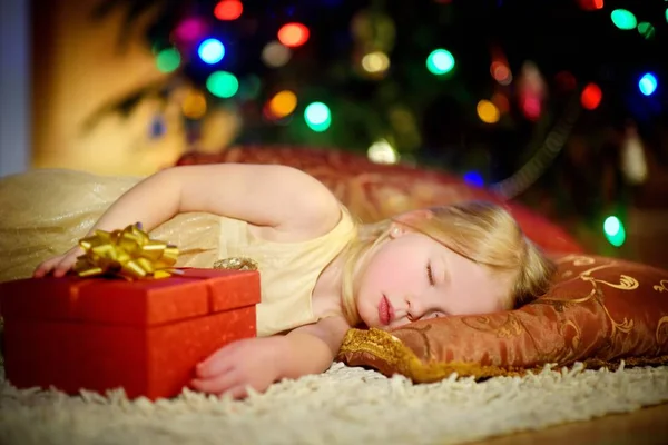 Mała dziewczynka spanie pod choinkę — Zdjęcie stockowe