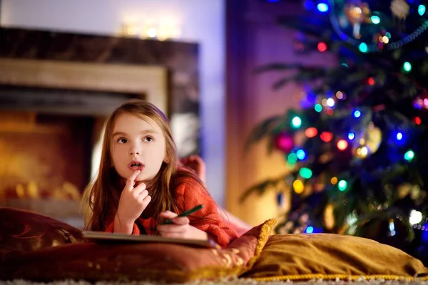 Sevimli kız Noel Baba'ya bir mektup yazma — Stok fotoğraf