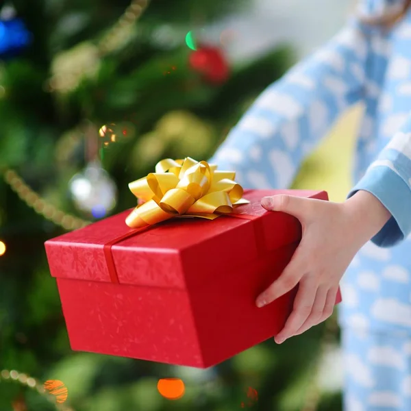 Niño en pijama sosteniendo regalo de Navidad —  Fotos de Stock